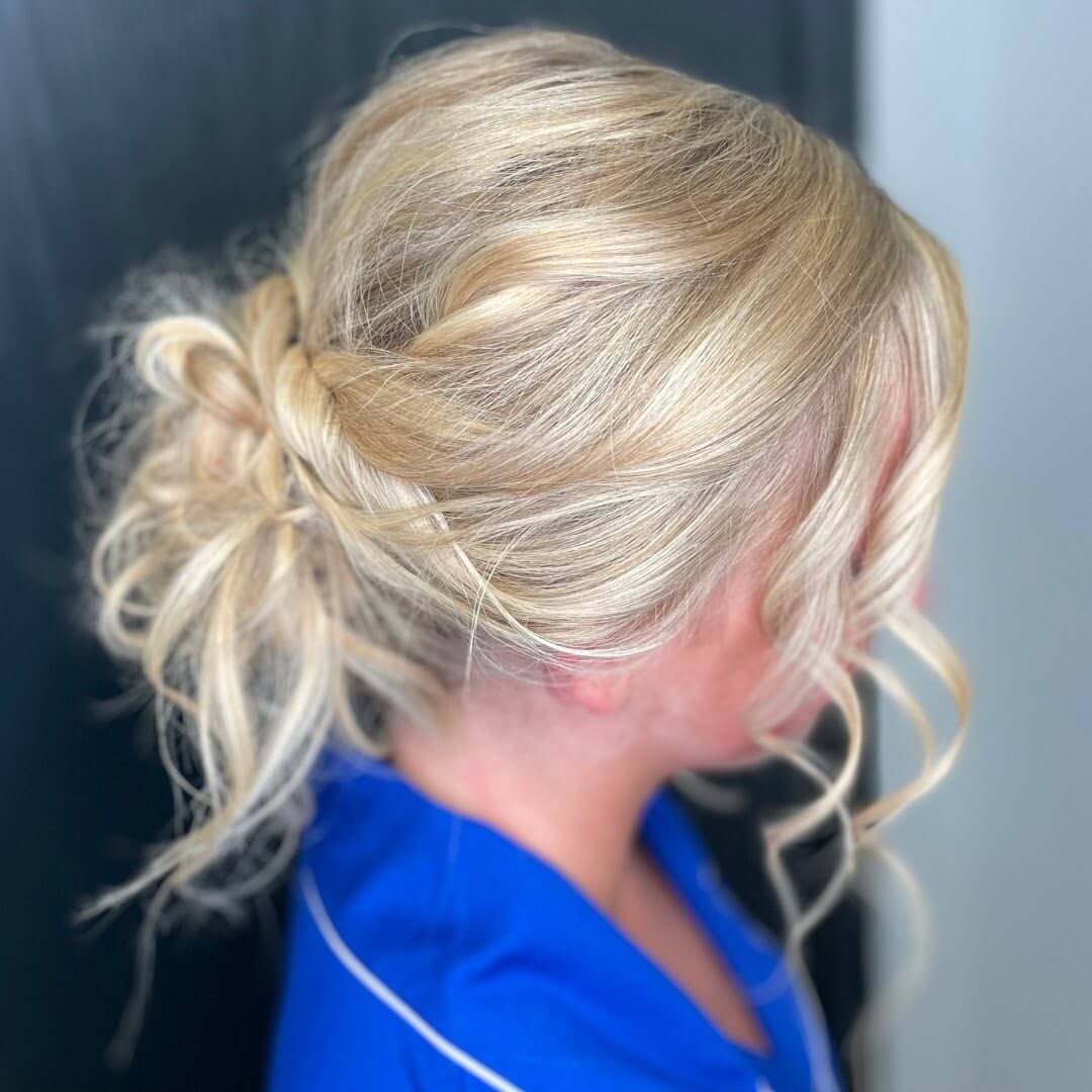 Tousled blonde updo with whimsical tendrils