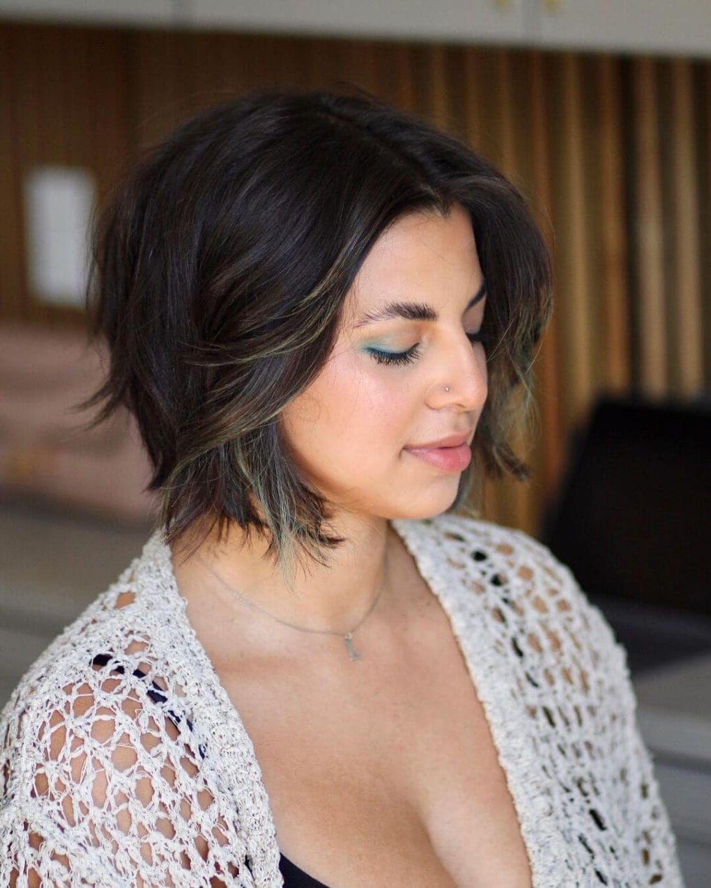 Relaxed tousled layered bob with a dark base and subtle highlights.