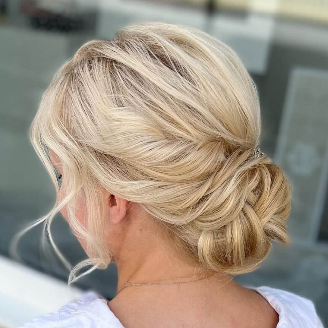 Twisted blonde low bun with soft framing strands