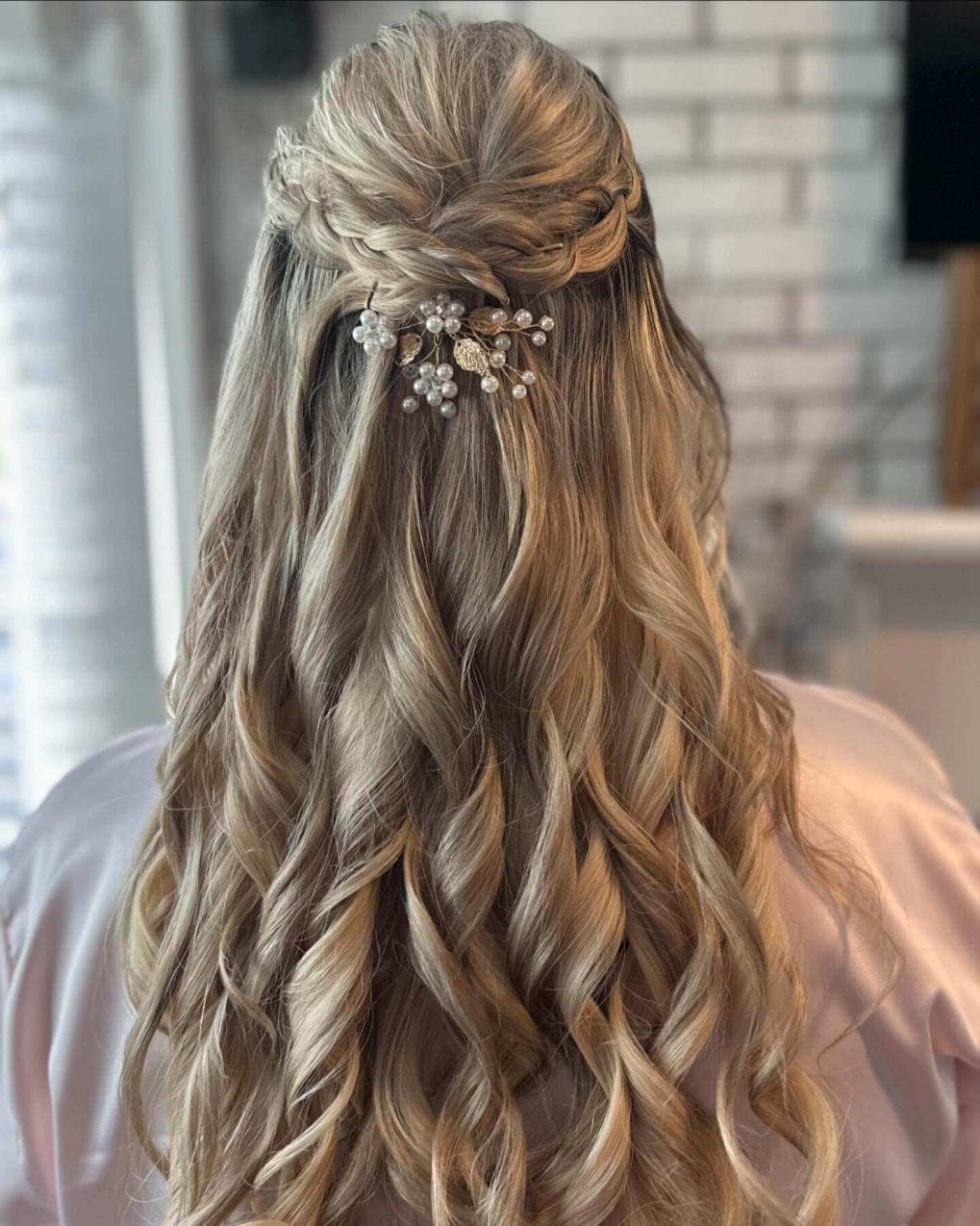 Romantic twisted braid with curls and golden hair accessory