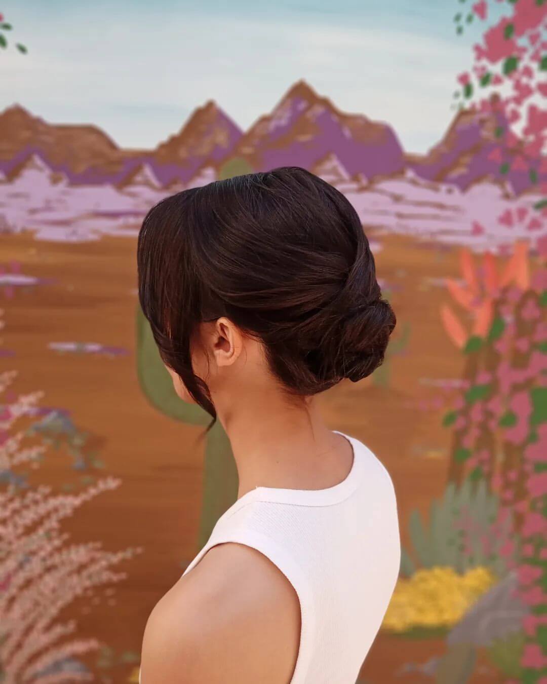 Neatly twisted low bun with romantic loose strands