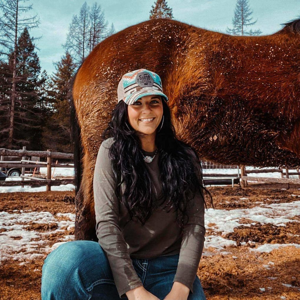 Cowgirl with untamed jet-black hair and full mane under cowboy hat