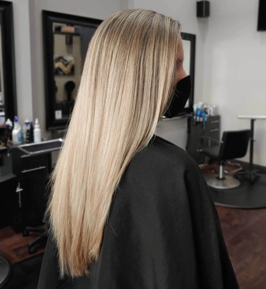 Flowing hair in a V-cut with seamless blonde-on-blonde highlights.