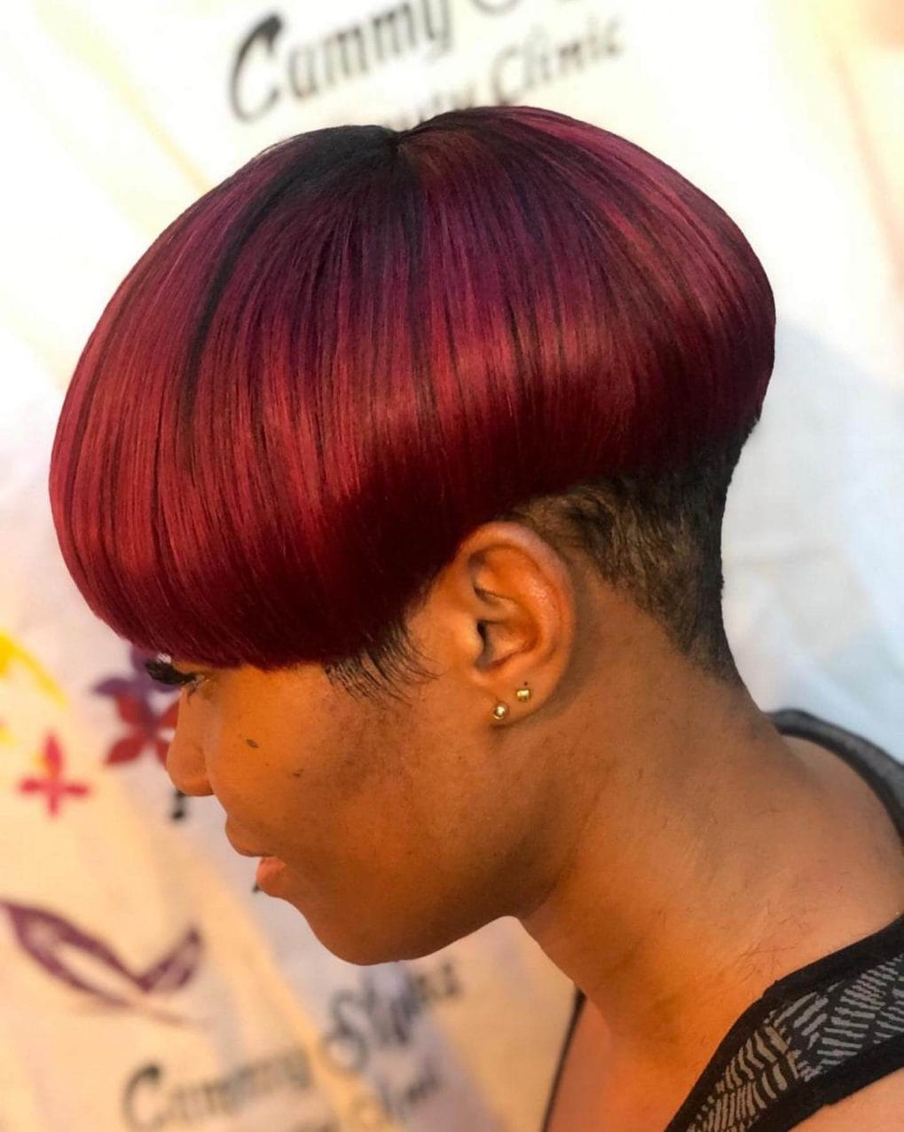 Striking mushroom hairstyle with vibrant burgundy and red shades.