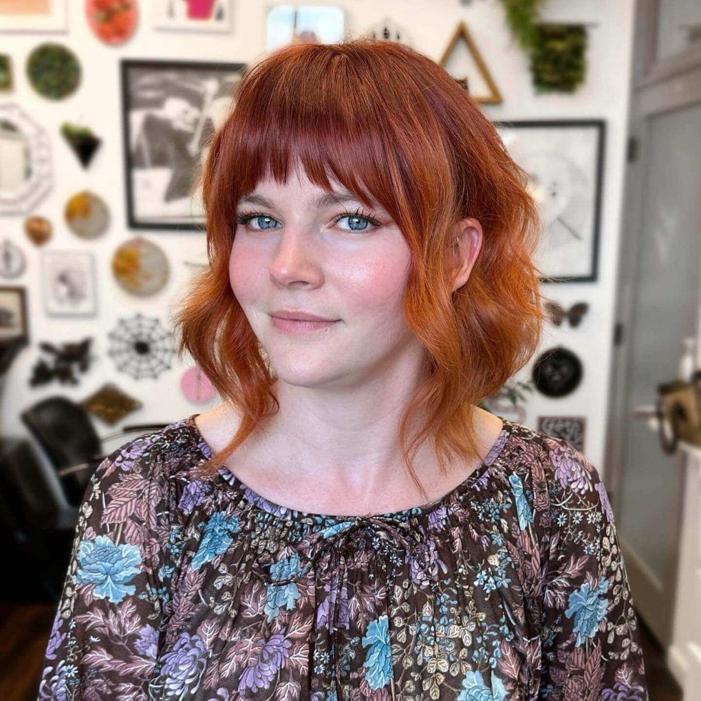 Playful copper curls with bold straight-across fringe.