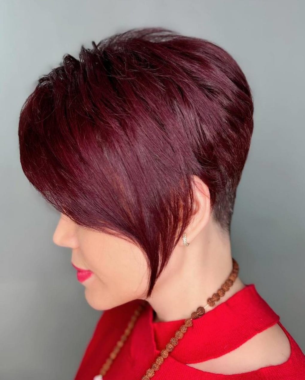 Vibrant red wedge with side-swept bangs and wavy texture