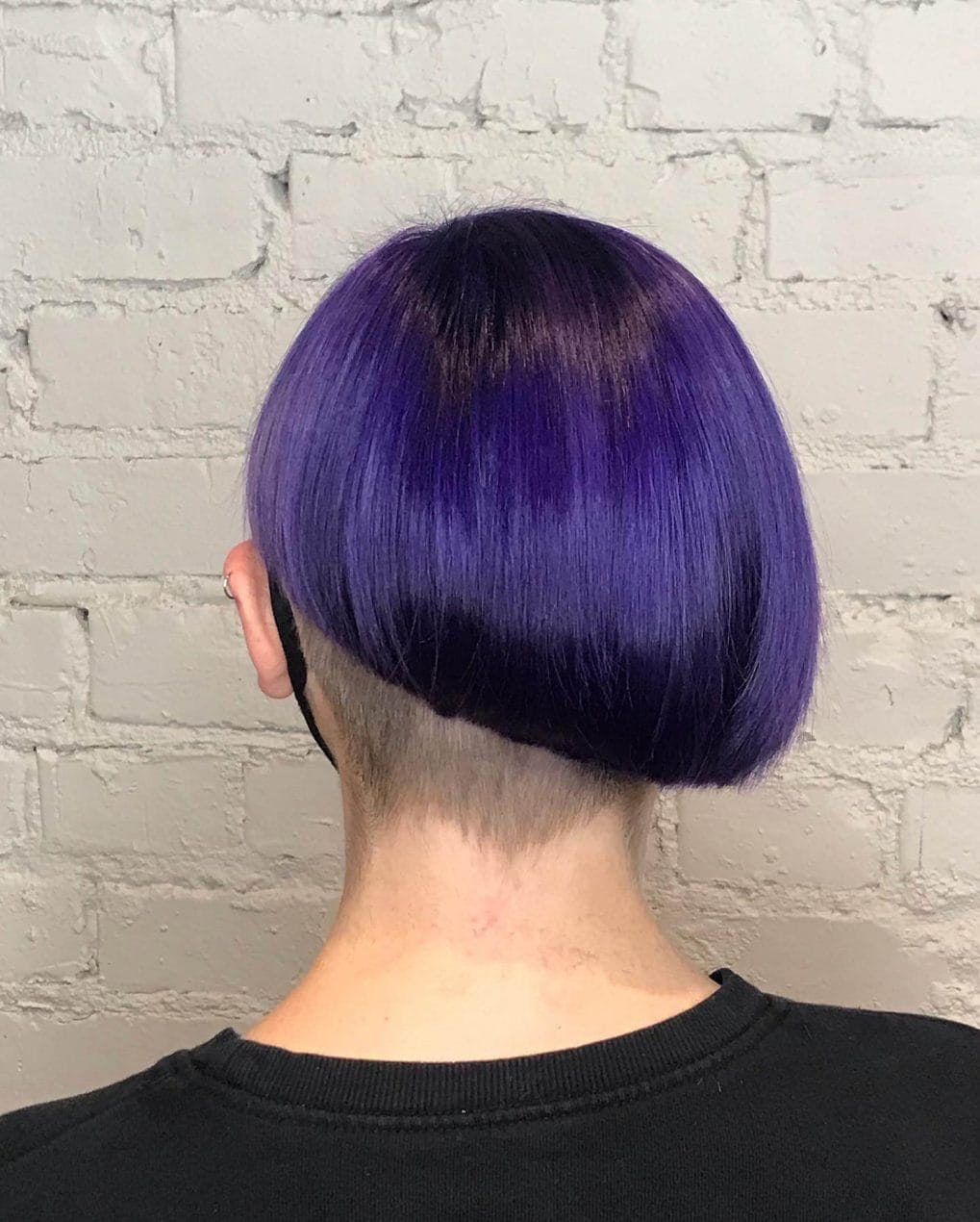 Vibrant violet bob with a smooth, rounded silhouette and a sharply shaved undercut.
