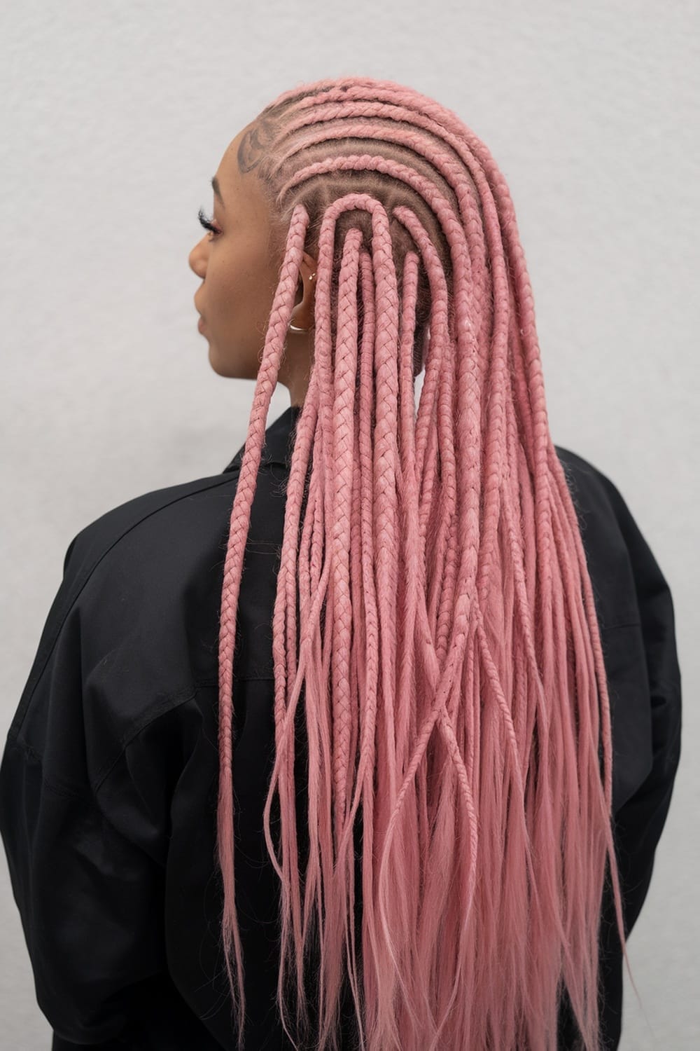 A woman with long pink cornrows styled beautifully.