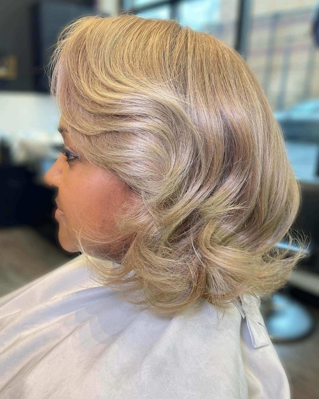 Short voluminous silk press bob in cool blonde with graduated layers and lively bounce