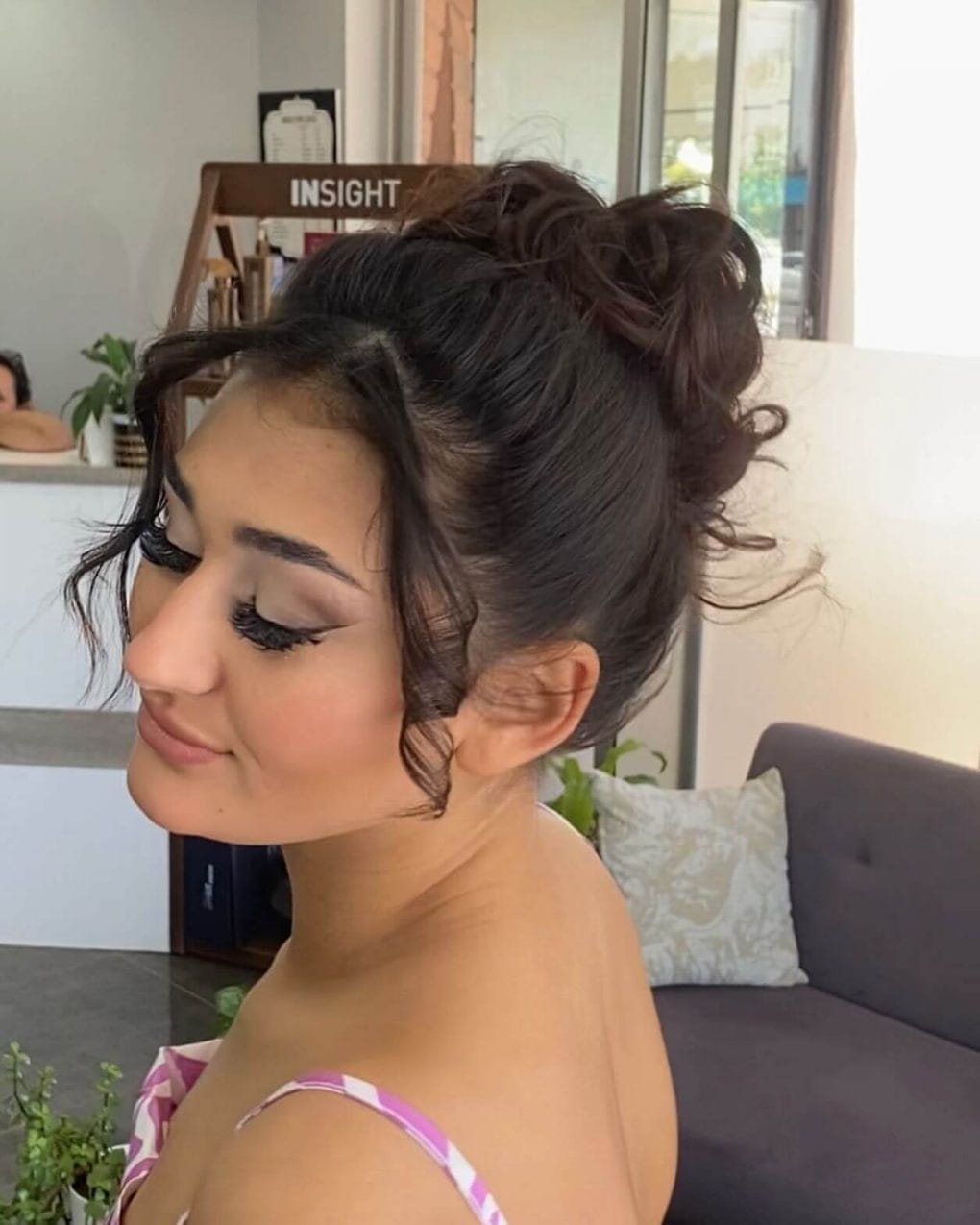 Voluminous bun with loose curls framing the face for new year's eve.