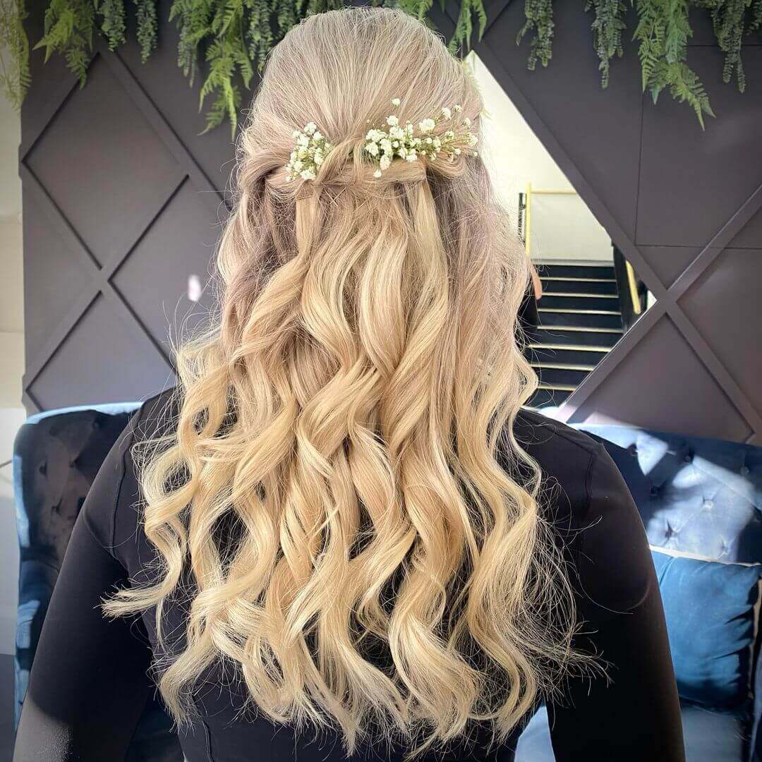 Voluminous curls with floral accents and highlights.