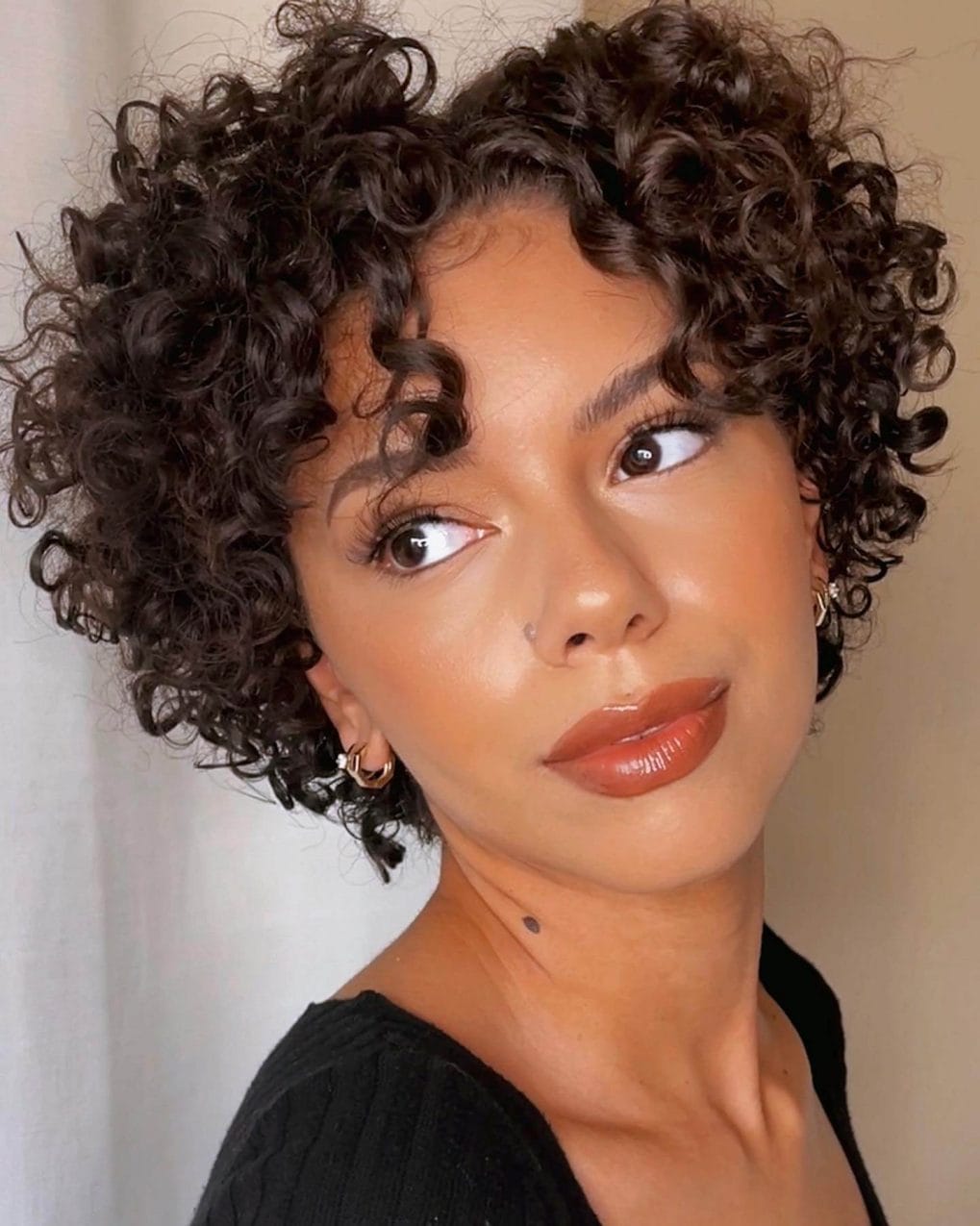 Voluminous curly bob with deep brunette shade.
