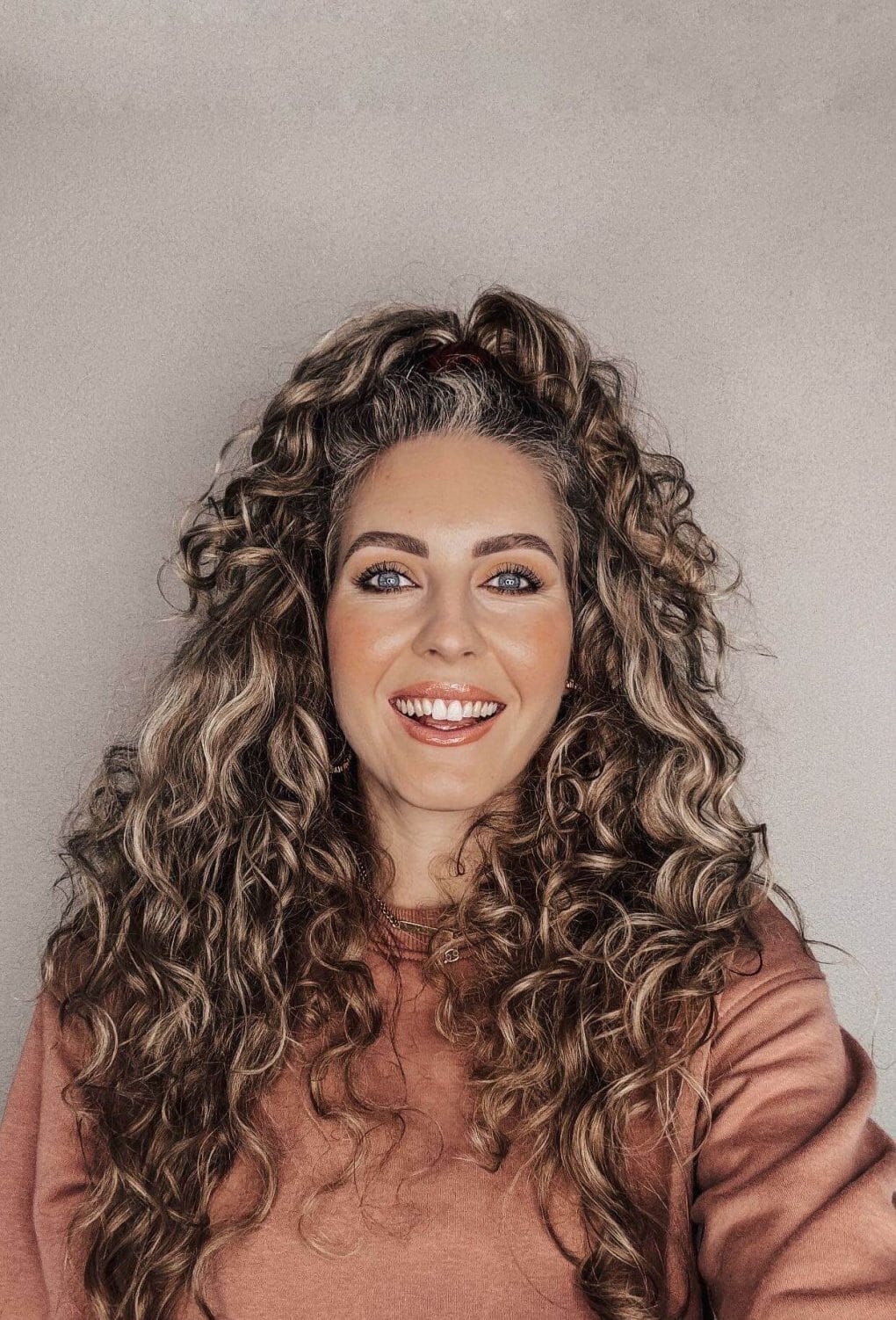 Voluminous curly half-up style for lively summer statement