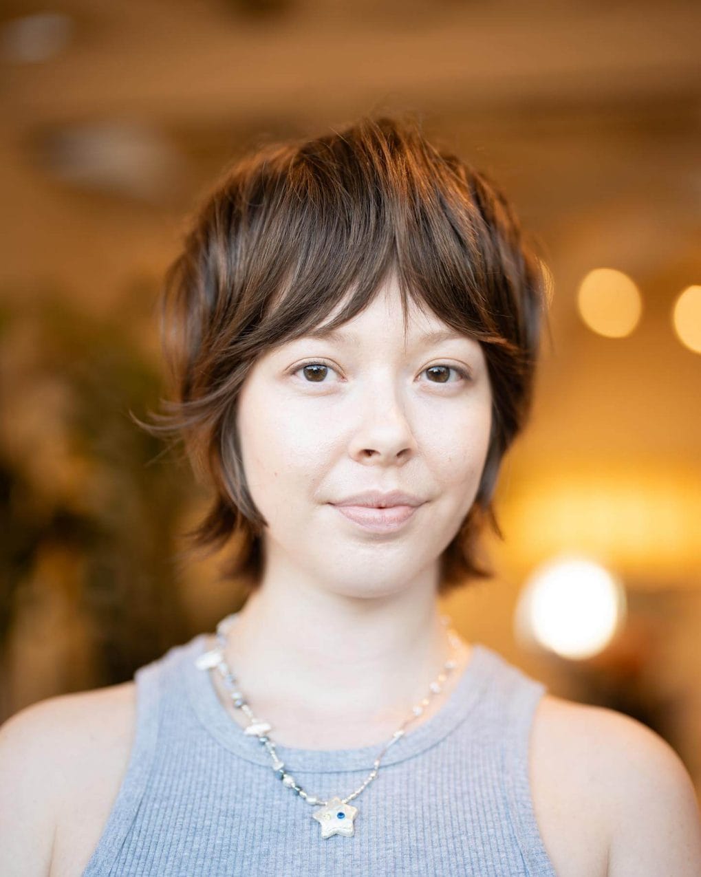 Stylish feathered pixie with soft middle-parted bangs.