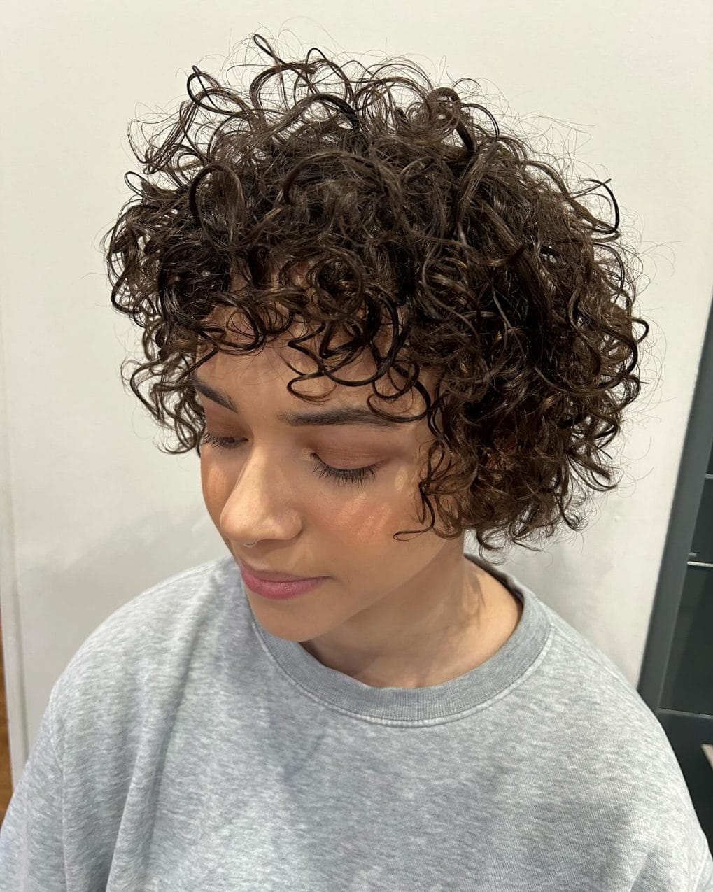 Balanced warm brown curly pixie enhancing natural ringlets