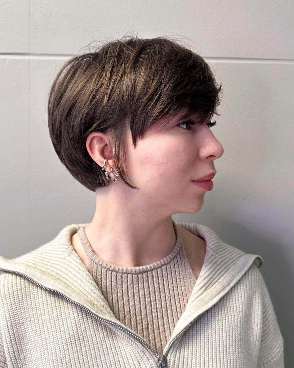 Layered asymmetrical pixie with warm browns around the cheek