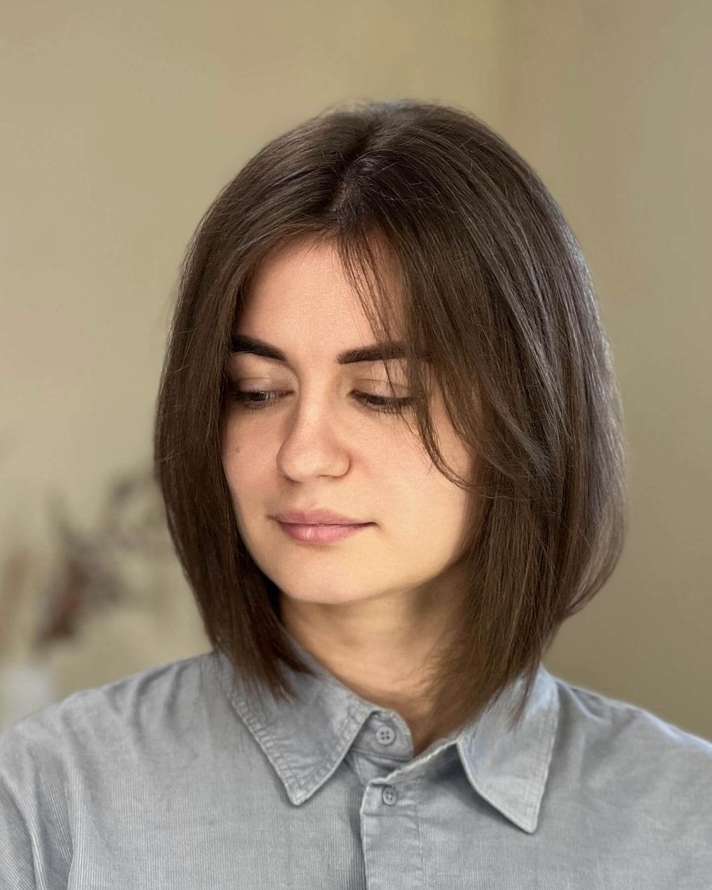 Warm layered '90s bob past chin with side-swept bangs