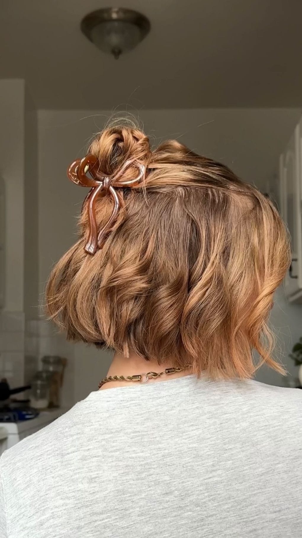 Short wavy bob pinned up with a tortoiseshell clip, trendy and gym-ready