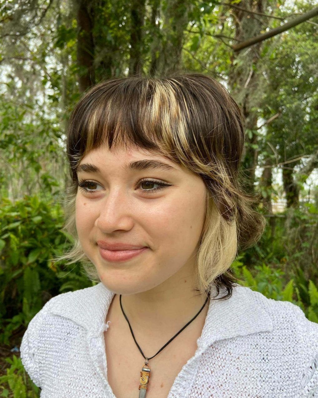 Wavy chin-length mix of brown and blonde with curtain bangs