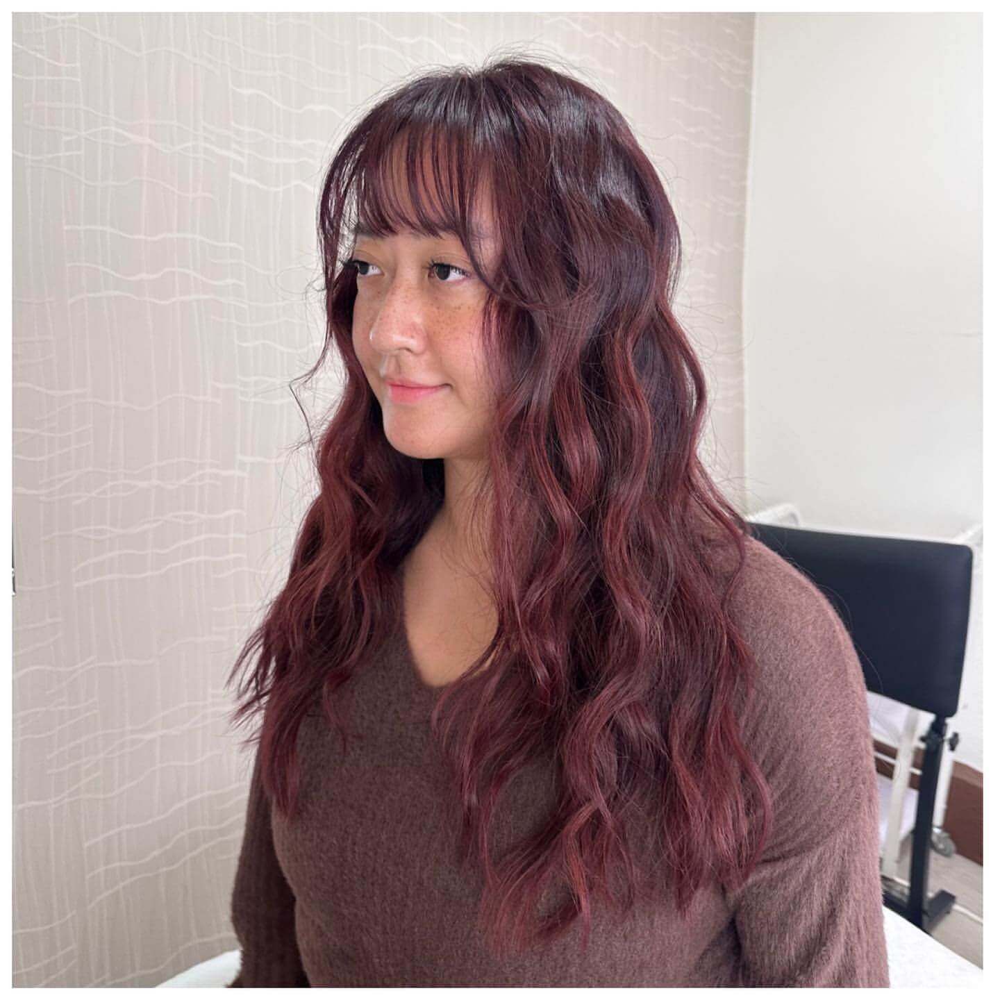 Long wavy burgundy hair with see-through bangs