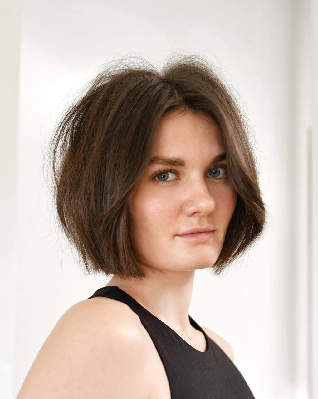 Relaxed wavy chin-length bob in deep brown with side parting