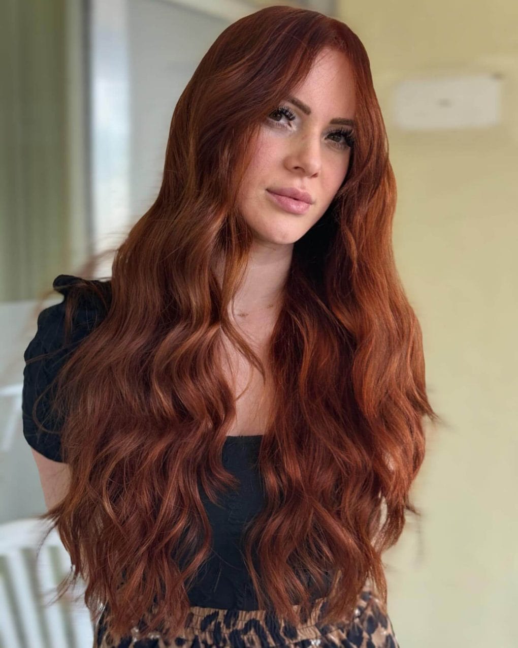 Wavy layers in vibrant copper with curtain bangs