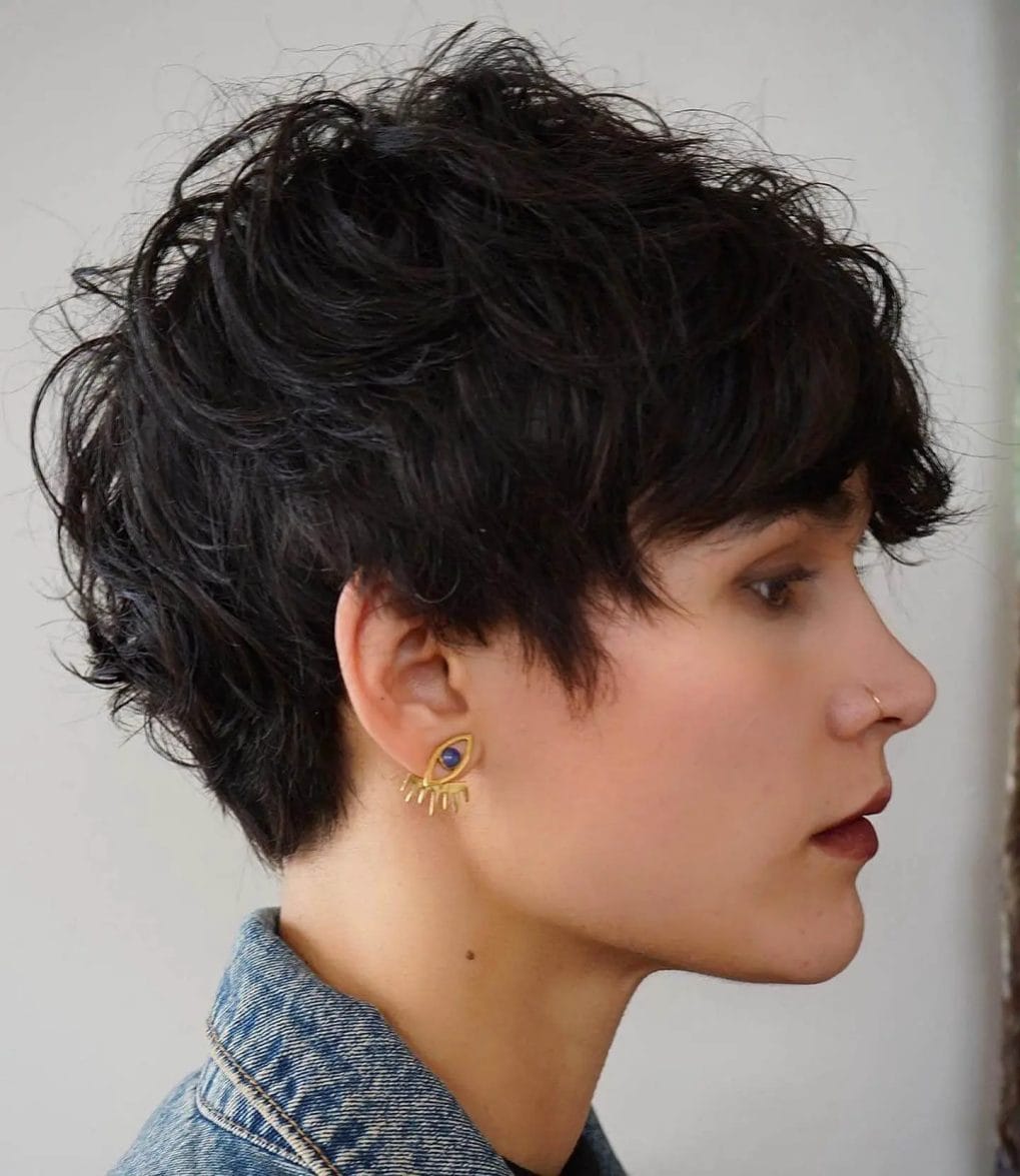 Black-haired wavy pixie with a standout front fringe and sideburns.