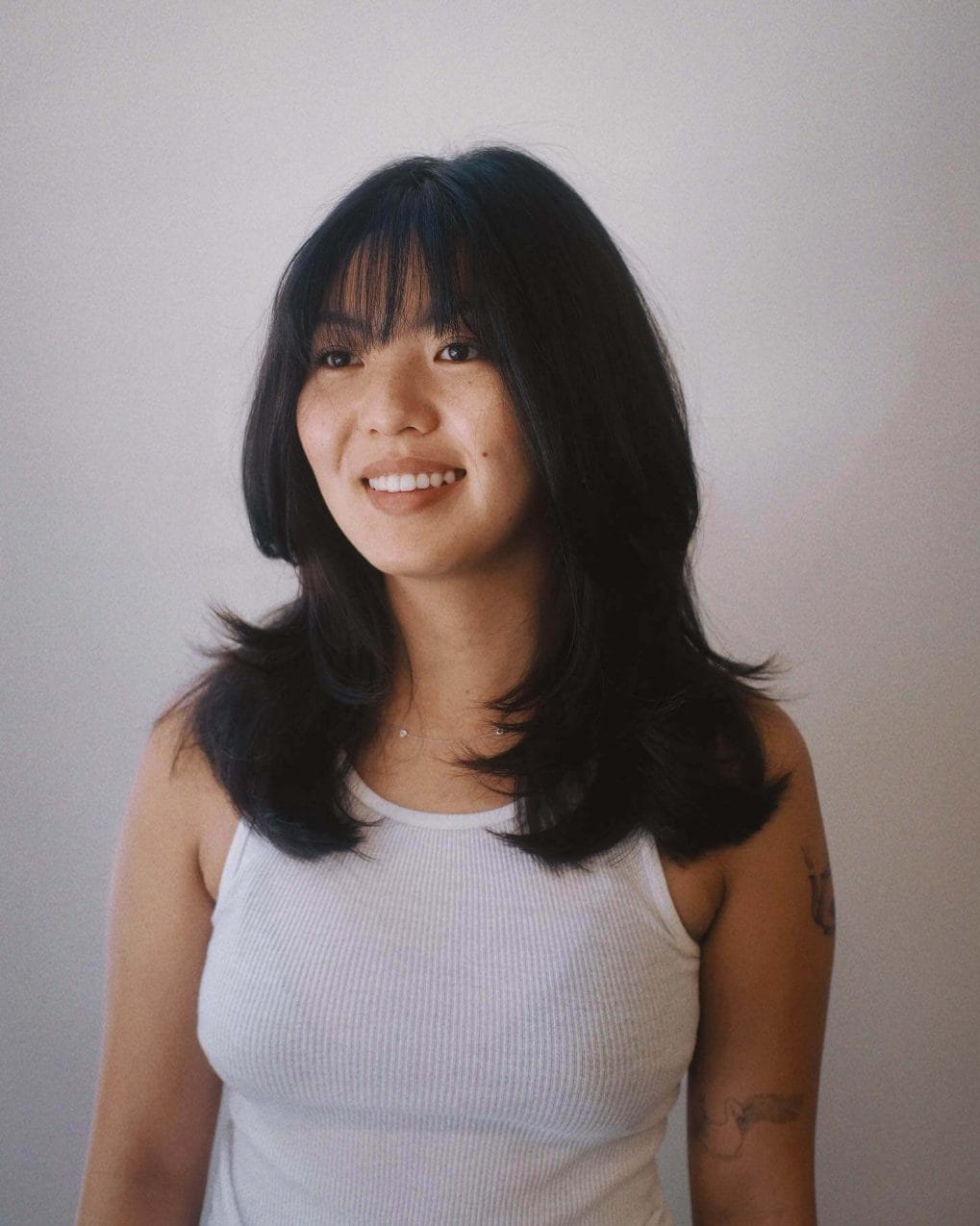 Playful wavy black hair with see-through bangs