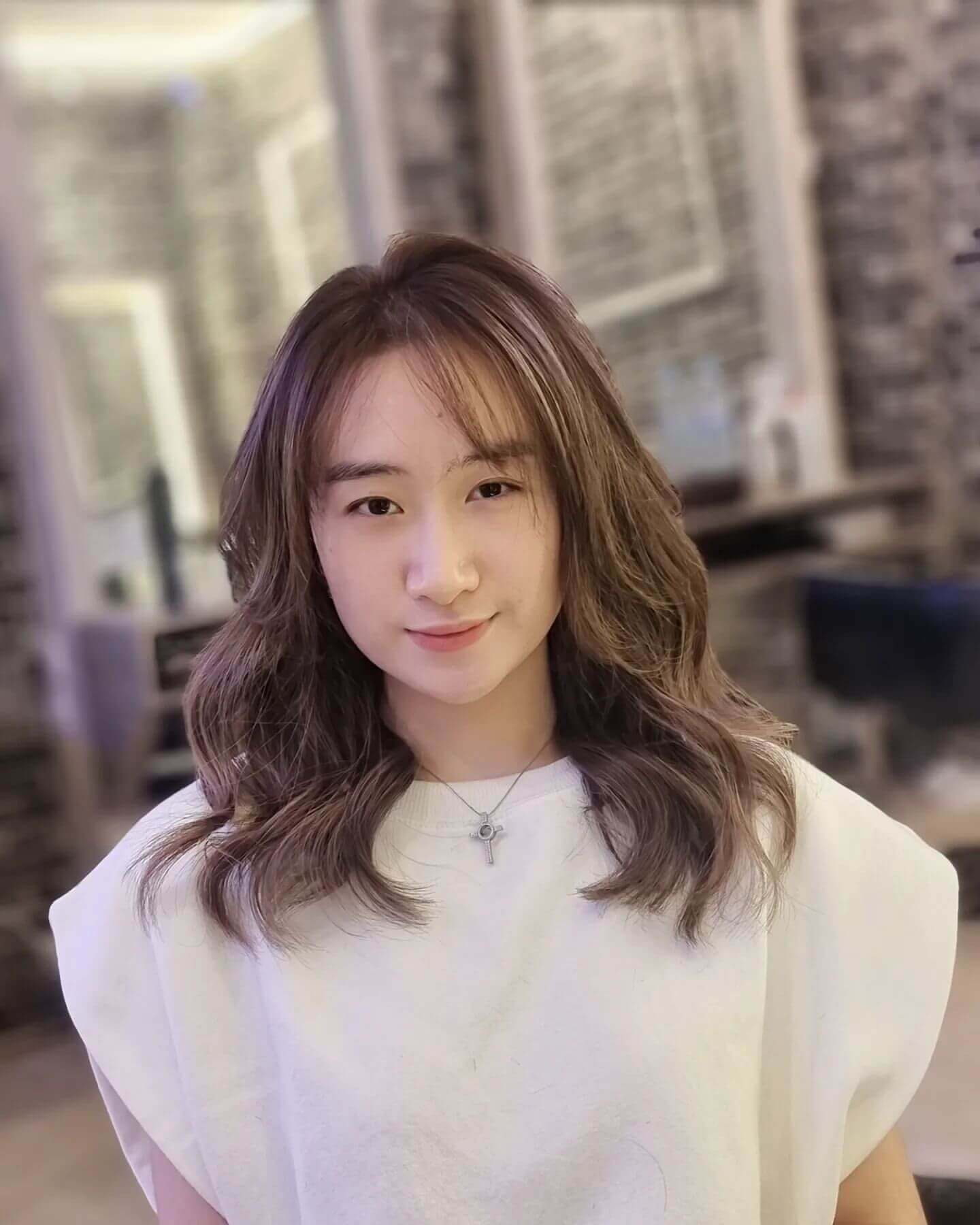 Medium-length wavy hair with see-through bangs