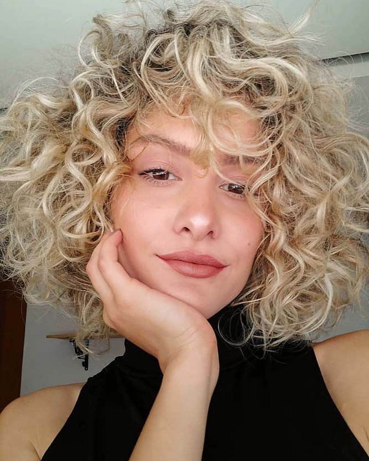 Platinum blonde hair with wild, loose curls.