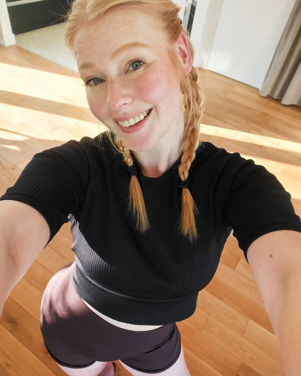 Blonde pigtail braids starting high, youthful and neatly secured for the gym